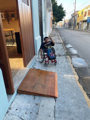 A wheelchair on a sidewalk next to a building with a ramp leading to the entrance. - Loft w/bathroom and kitchenette + accessibility (Merida)