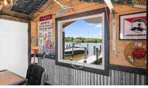 Ein Zimmer mit großem Fenster mit Blick auf ein Gewässer, rustikalem Holzinterieur und einem Schild, das Gäste willkommen heißt.