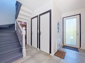 Eine Treppe, die zu einer Zwischenebene mit einer Tür und einem Glastür-Eingang führt.