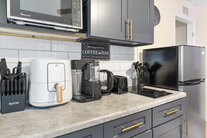 A kitchen with a coffee bar sign, a microwave, a toaster, and a refrigerator. - Your Ybor Base - WFH & Pet Friendly - Kitchenette (Tampa)