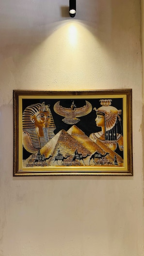 A framed ancient Egyptian artwork on a wall.