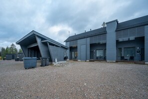 A modern building with a sloped roof and a gravel driveway.