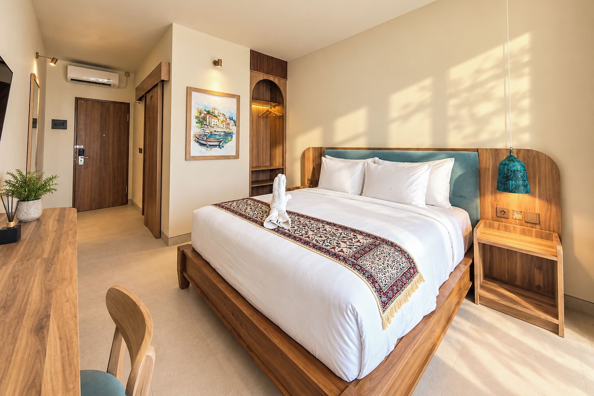 A hotel room with a wooden bed, a desk, and a chair.