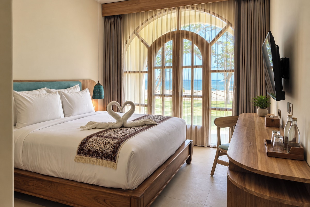 A hotel room with a bed, a desk, a chair, and a view of the outdoors.