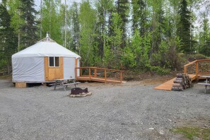 A small, covered structure with a wooden door and a ramp leading to a wooden platform.