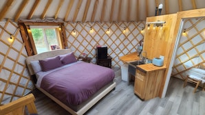 A yurt with a bed, desk, and kitchenette. - A cozy yurt with all of the amenities (Big Lake)