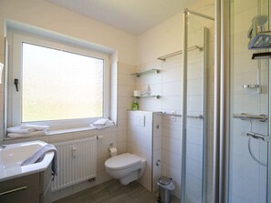 A modern bathroom with a toilet, bidet, and a glass shower enclosure. - Amrum / Wittdun (Wittduen)