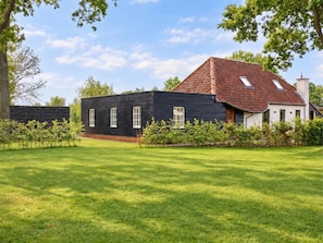 A modern two-story house with a dark facade and a red-tiled roof. - Rust, space, and comfort in Balen. (Balen)