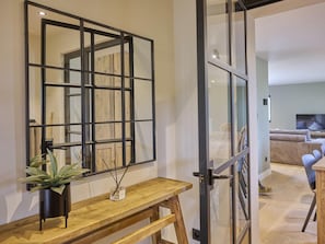 A modern living room with a large window, a wooden bench, and a mirror on the wall. - Rust, space, and comfort in Balen. (Balen)