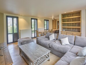 A spacious living room with a large sofa, a coffee table, and a wooden cabinet. - Rust, space, and comfort in Balen. (Balen)