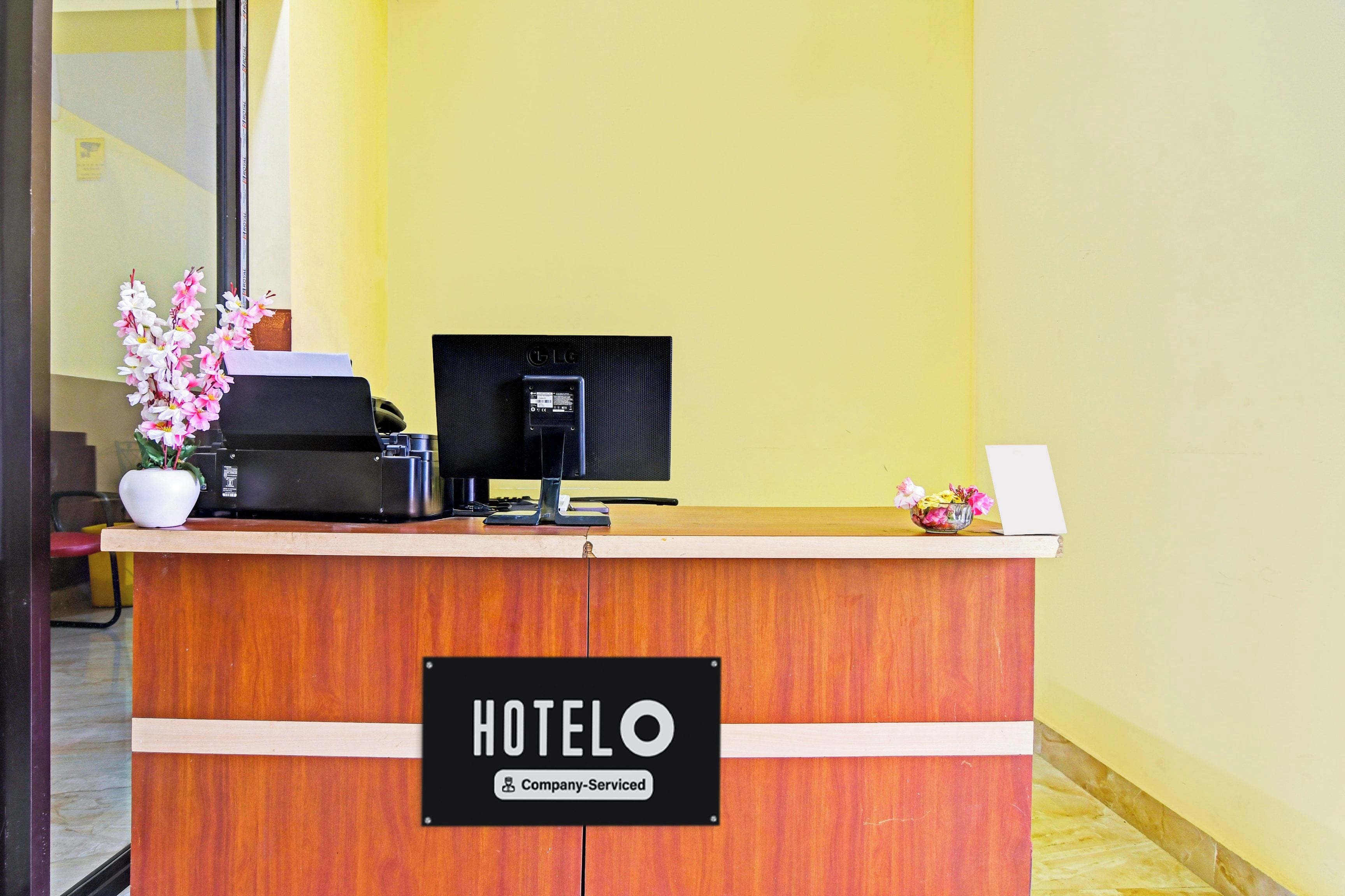 A hotel reception desk with a sign indicating it is company-serviced.
