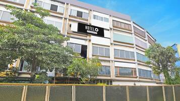 A multi-story hotel building with a sign that reads 'HOTEL' and 'Company Serviced.'