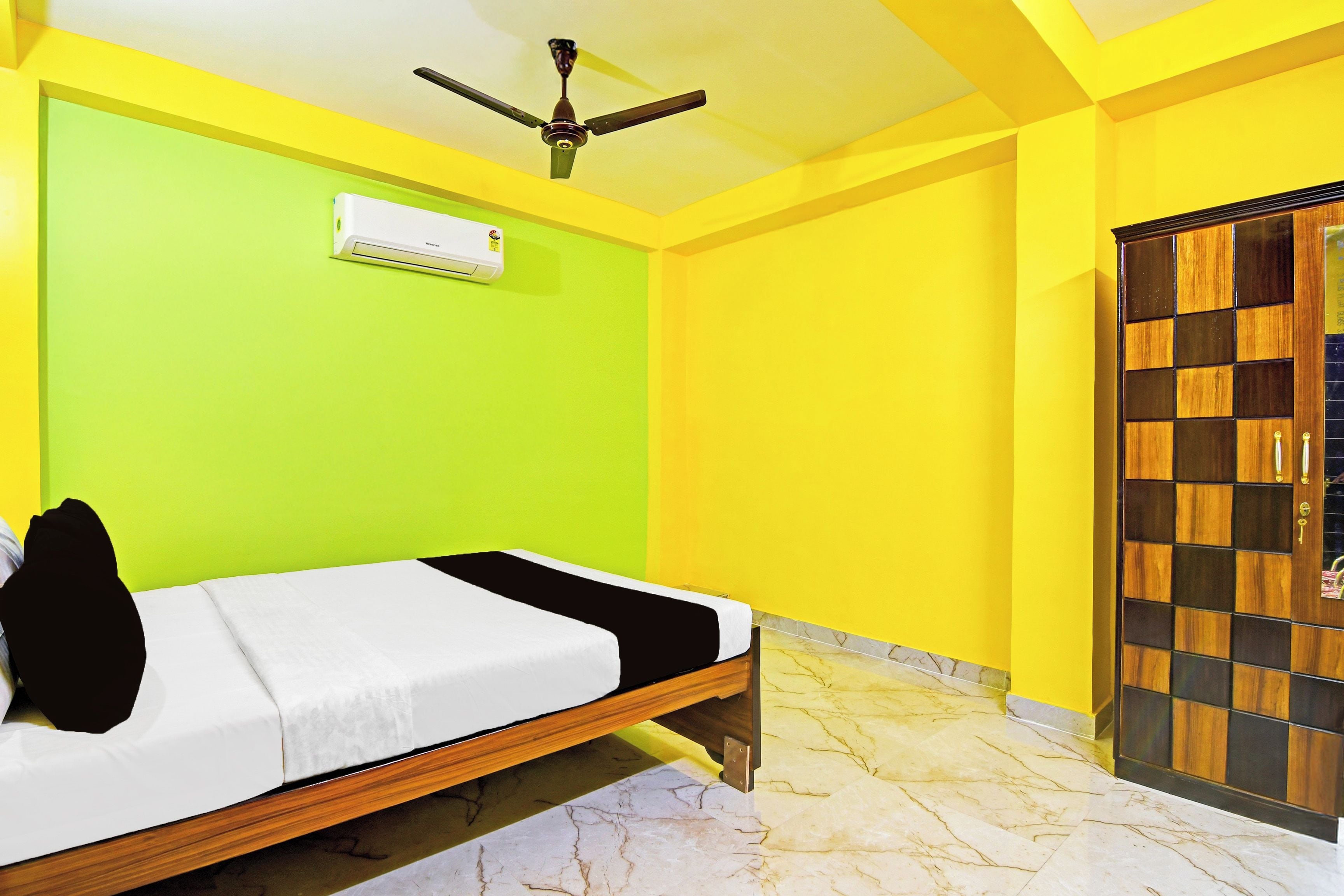 A room with a bed, a ceiling fan, and a wardrobe.