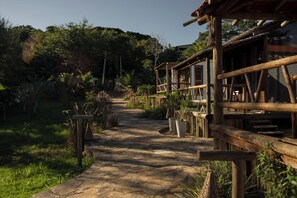 A rustic wooden pathway leading to a traditional building with a thatched roof.