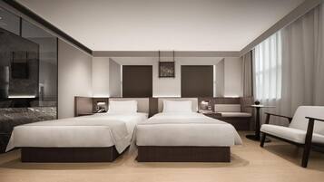 A modern hotel room with two beds, a seating area, and a large window.
