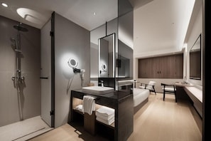 Une salle de bain moderne équipée d’une douche, d’un lavabo, d’un miroir et d’un meuble-lavabo.