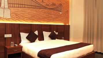 Habitación de hotel con una cama grande, cabecera de madera, mesitas de noche, ventilador de techo y un mural en la pared de un puente.