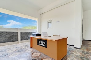 A reception desk with a 'HOTEL' sign, a laptop, and a 'RECEPTION' sign on the wall. - Hotel O Neelambur Near PSG ITech (Sulur)