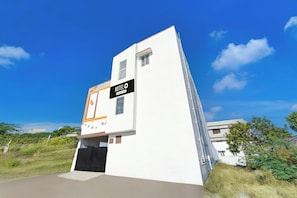 A modern building with a sign indicating it is a hotel. - Hotel O Neelambur Near PSG ITech (Sulur)