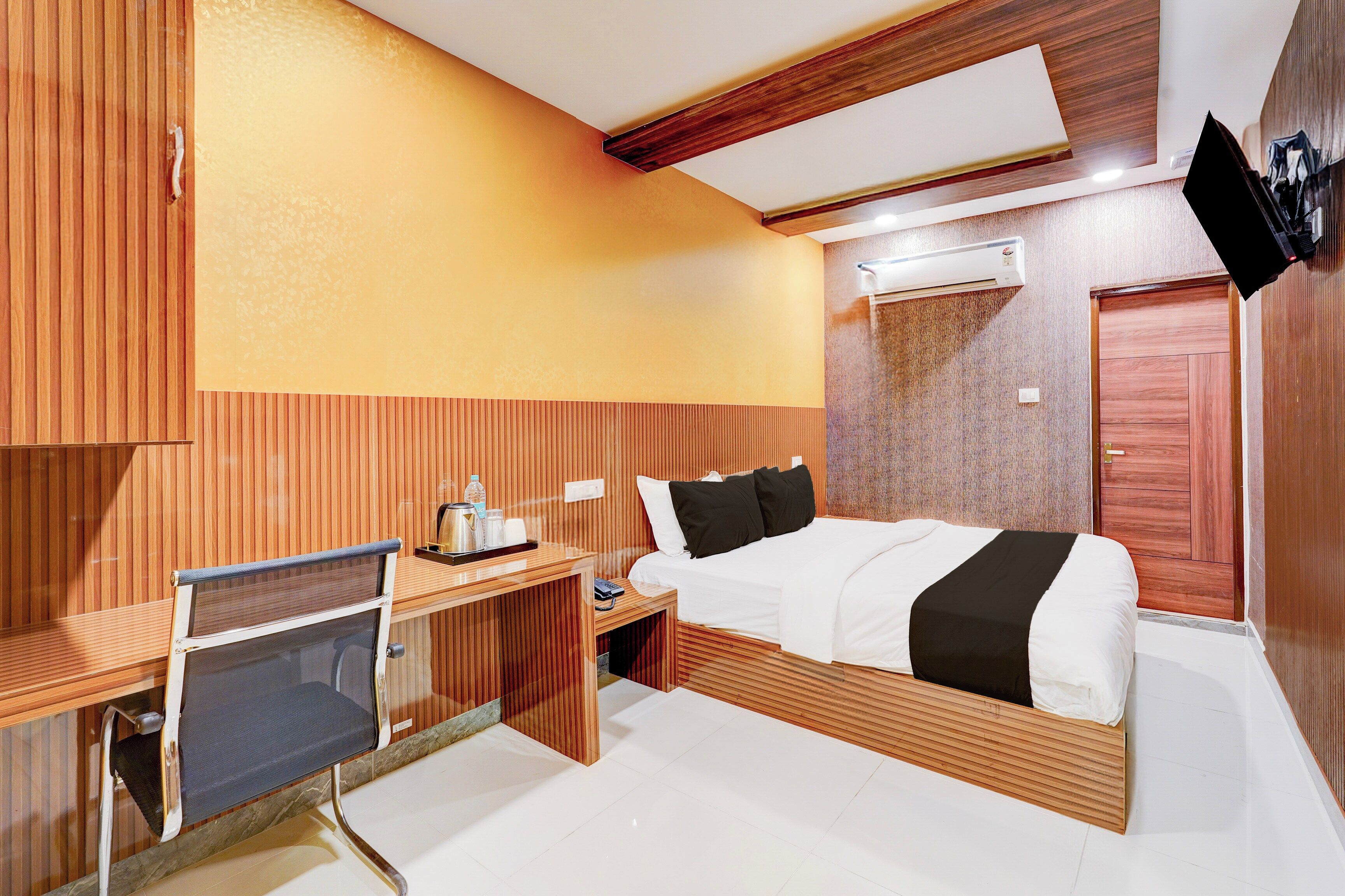 Une chambre d’hôtel équipée d’un lit, d’un bureau, d’une chaise et d’un appareil de climatisation.