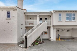 A residential building with a central staircase, a garage, and a parking area. - Pilgrims Apartments (Griffith)