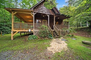 A wooden cabin with a porch, a covered deck, and a gravel pathway leading to the entrance. - Peaceful Foscoe Retreat with Hot Tub (Boone)