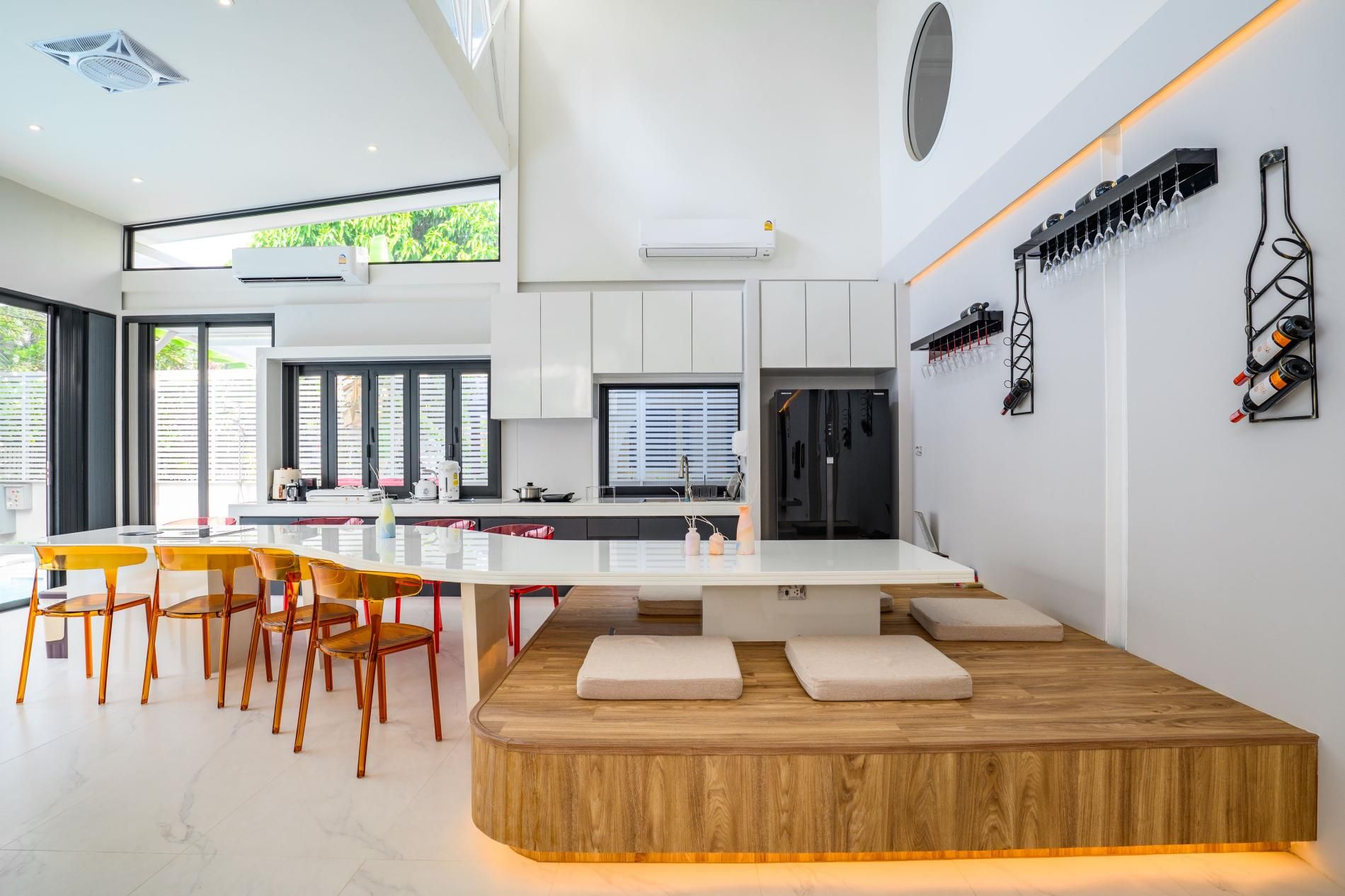 Une cuisine moderne dotée d’un îlot central, d’appareils électroménagers intégrés et d’un meuble à vin.