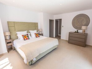 A hotel room with a bed, bedside tables, a dresser, and a decorative wall piece. - Holiday Home in Grimaud With Swimming Pool (Grimaud)