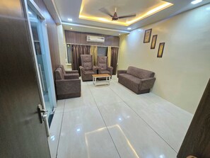 A modern living room with a sofa, armchairs, and a coffee table.