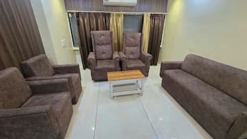 Una sala de estar con dos sillones, un sofá y una mesita de centro.