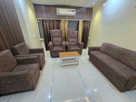 Una sala de estar con dos sillones, un sofá y una mesita de centro.