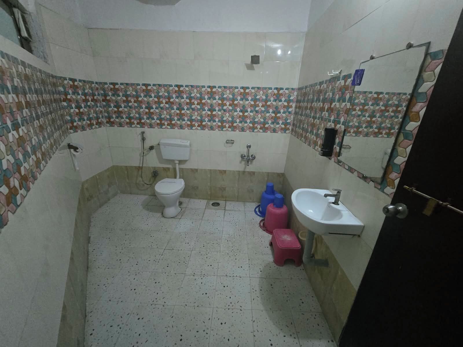 A small bathroom with a toilet, sink, and tiled walls.
