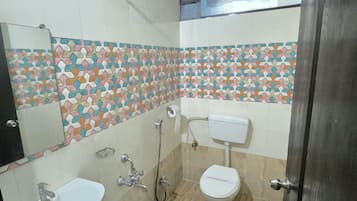Un baño con lavamanos, inodoro, ducha y paredes de azulejos.