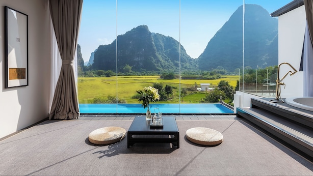 A modern room with a large window, a view of a mountain, and a pool. - Yangshou Mountain Vista Courtyard (Guilin)