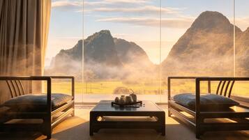Une pièce avec deux canapés placés face à une grande fenêtre donnant sur un paysage montagneux.