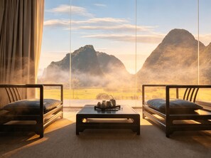 Habitación con dos sofás orientados hacia una ventana grande que da a un paisaje montañoso.