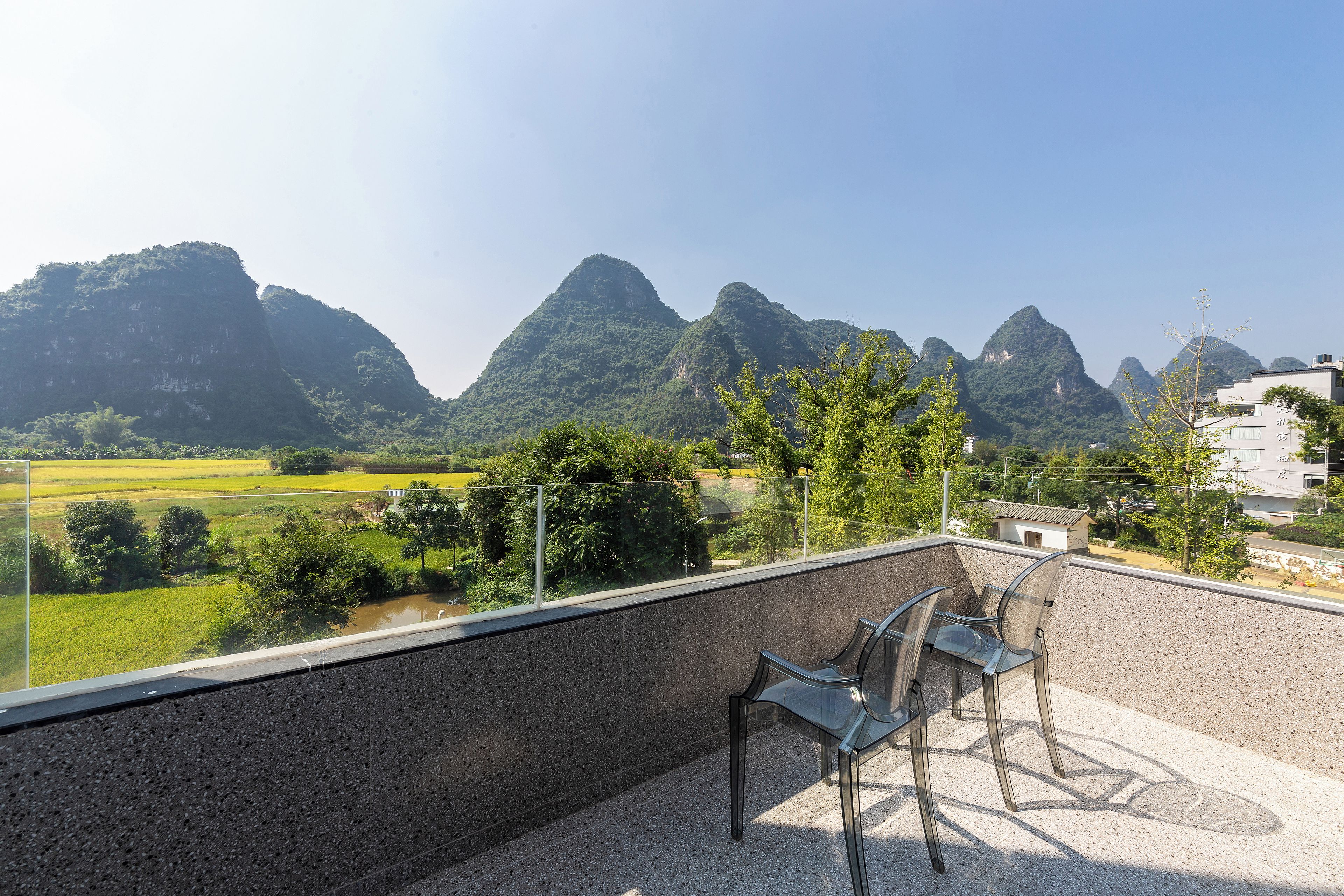 Una terraza con vistas a montañas y campos.