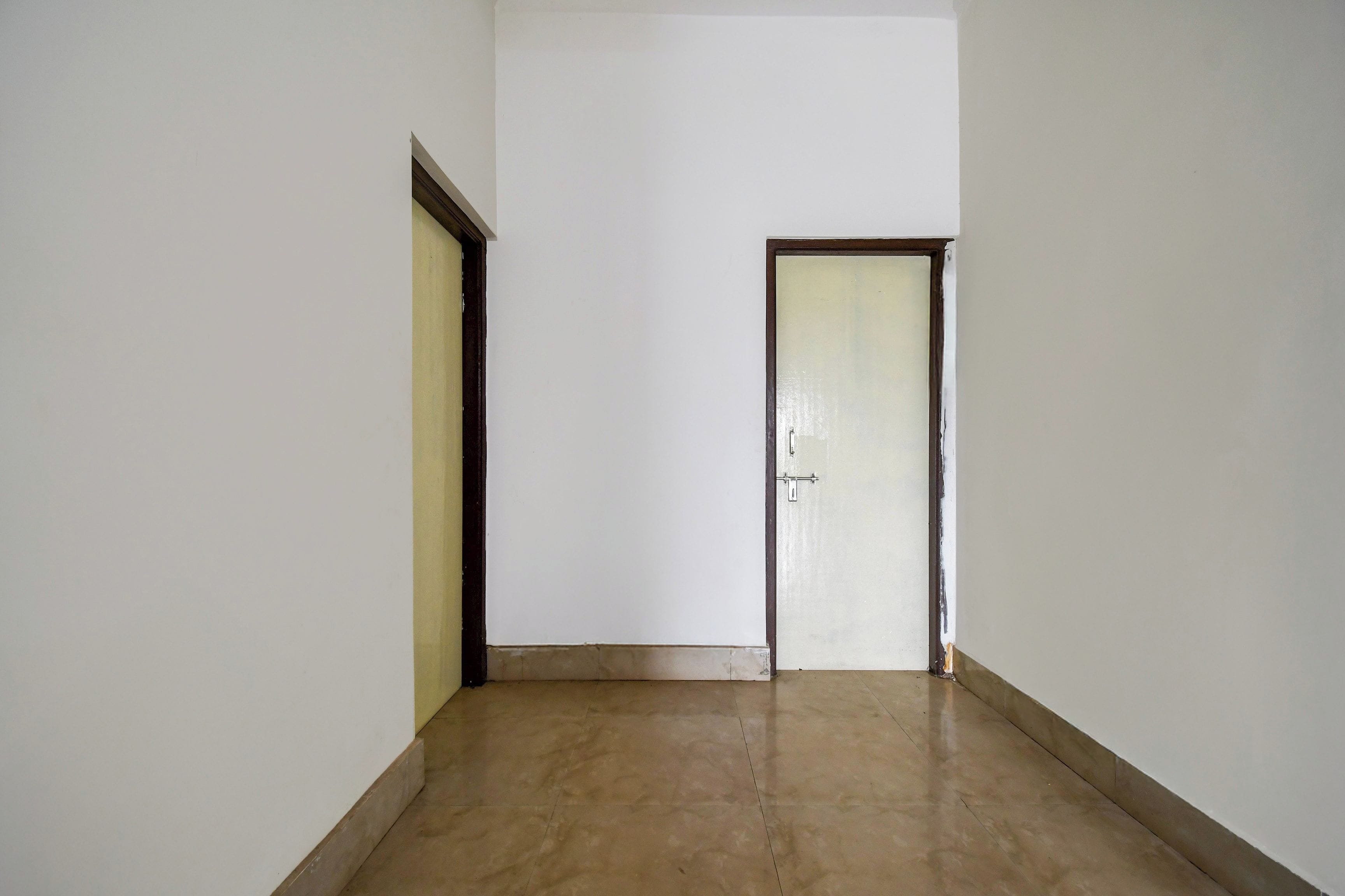 Un pasillo con suelo de baldosas y una puerta al final.