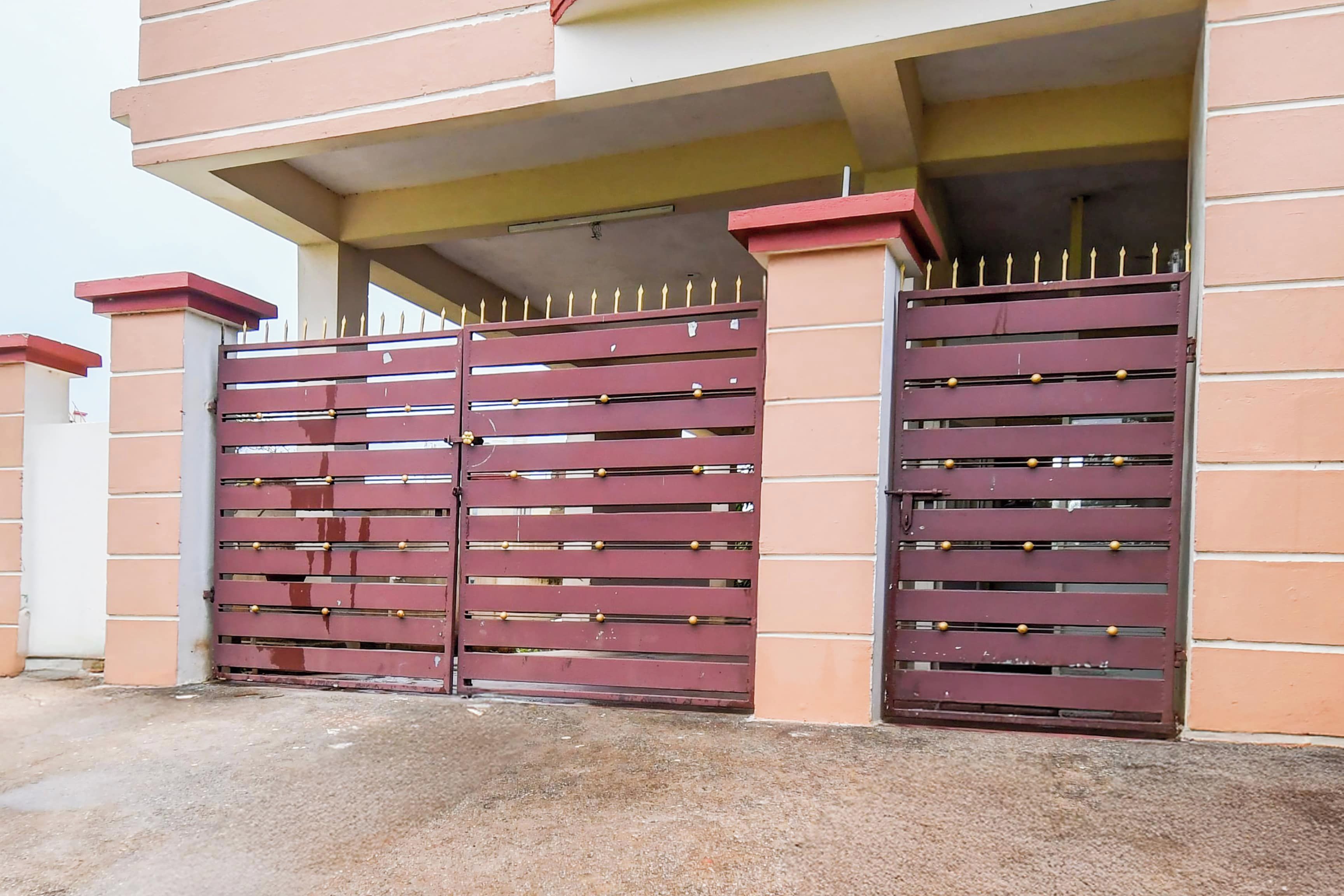 A gated entrance with a metal gate and a concrete floor.