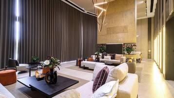 A modern living room with a sofa, coffee table, and decorative plants.