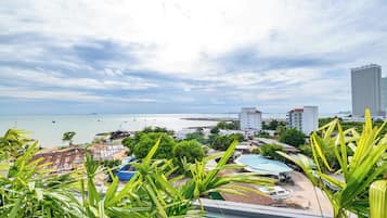 A coastal cityscape with a marina, buildings, and lush greenery.