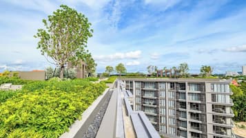 Ein modernes Gebäude mit flachem Dach, umgeben von viel Grün und blauem Himmel.