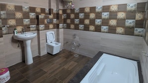 Une salle de bain avec une baignoire, un lavabo, des toilettes et une douche.