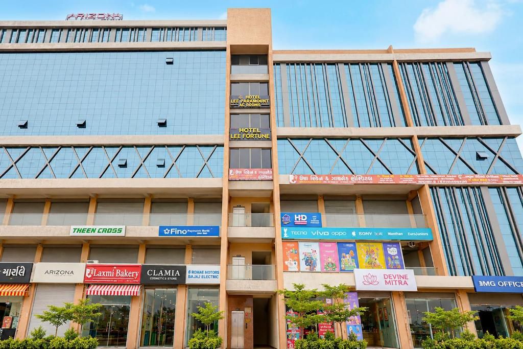 A multi-story building with various commercial establishments on the ground floor, including a bakery, a bank, and a hotel.