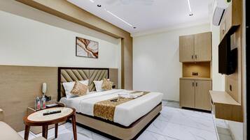A modern hotel room with a bed, bedside table, and a TV mounted on the wall.