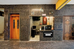A reception area with a reception desk, a sign indicating 'Reception', and a sign for 'Townhouse Oak'. - Townhouse Oak Tirupati Formerly Sky (Tirupati)