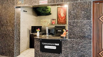 Un área de recepción con un letrero que indica 'Townhouse Oak' y 'Servicio de la empresa'.