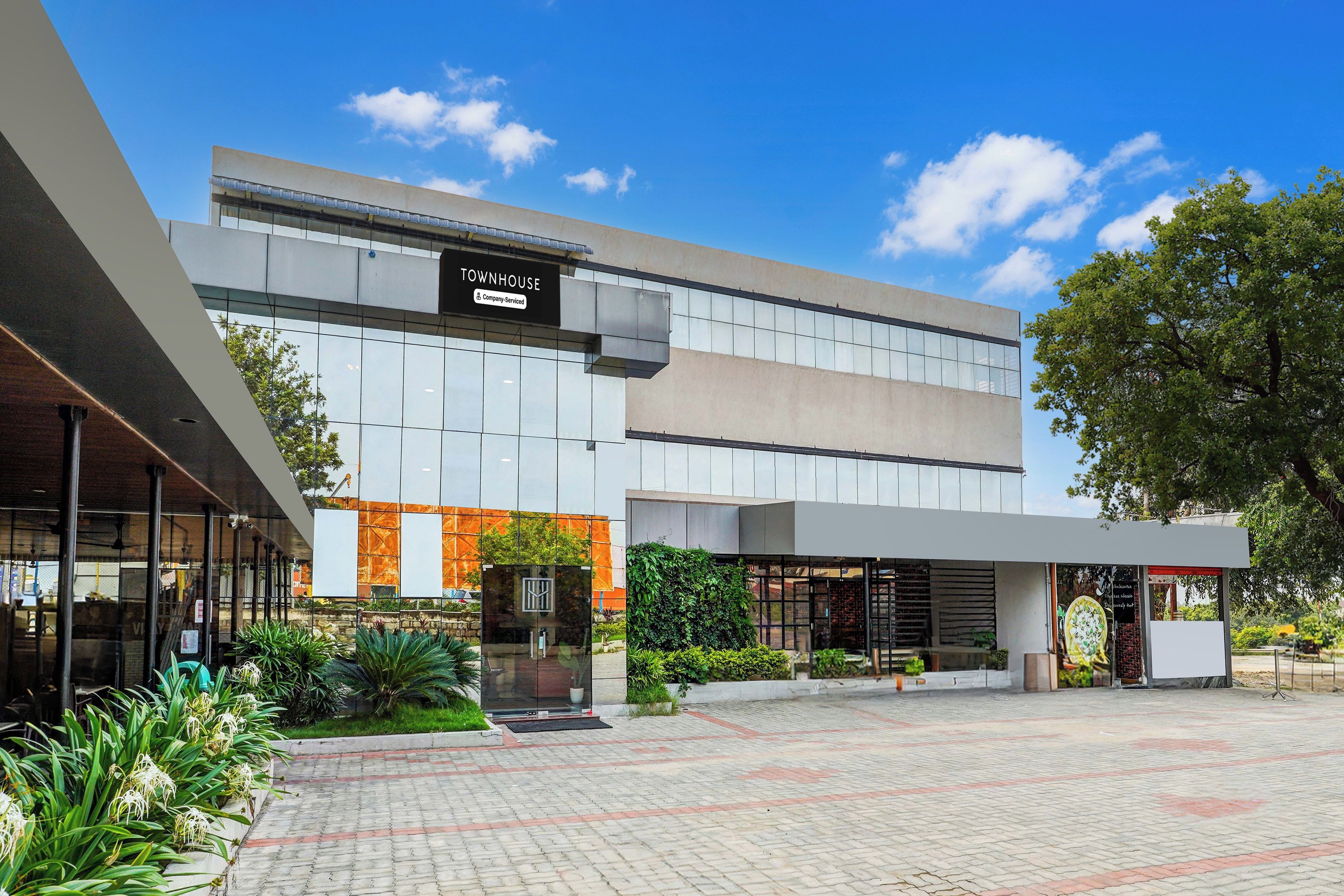 A modern building with a sign reading 'TOWNHOUSE Company-Serviced'.