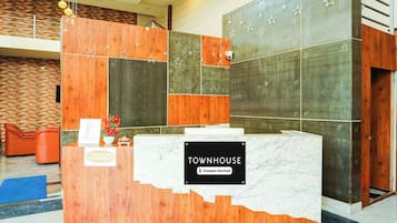 Bancada de recepção com placa indicando que é uma townhouse com serviços de empresa.