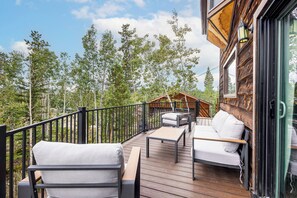 A wooden deck with outdoor furniture, a railing, and a view of trees. - Deck & Views! Family Retreat Near RMNP (Grand Lake)